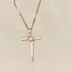 silver cross about 4cm in length with a cubic zirconia in center